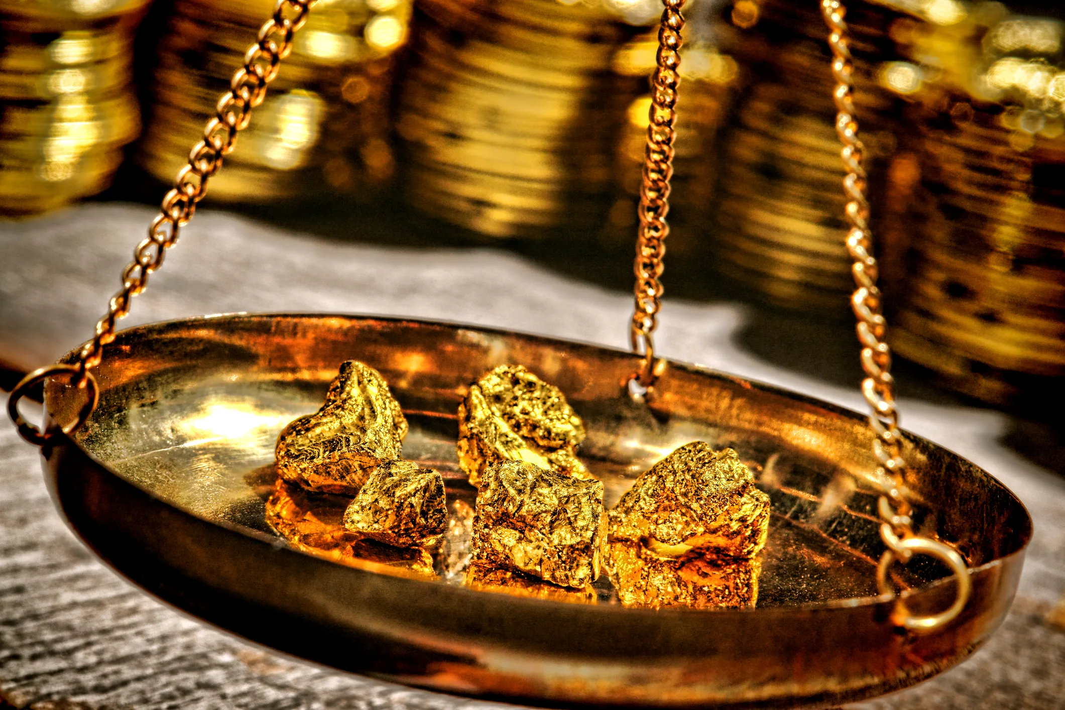 Gold on a scale with coins - weighing your investment options